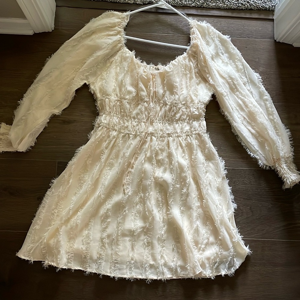 Cream colored long sleeve dress.